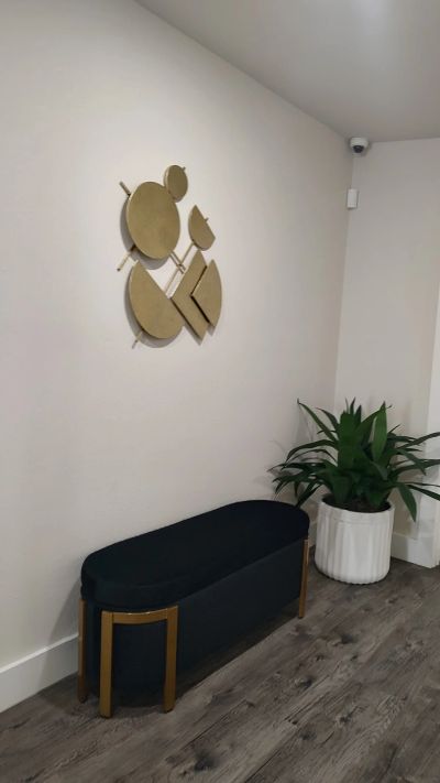 Velvet bench beneath gold disc wall art