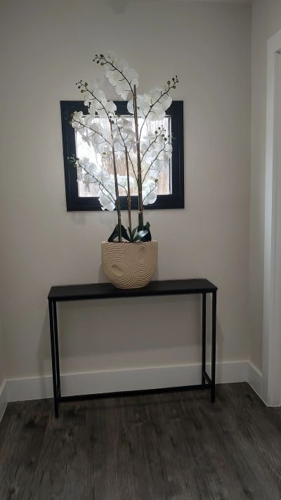 Black-framed mirror with orchid arrangement